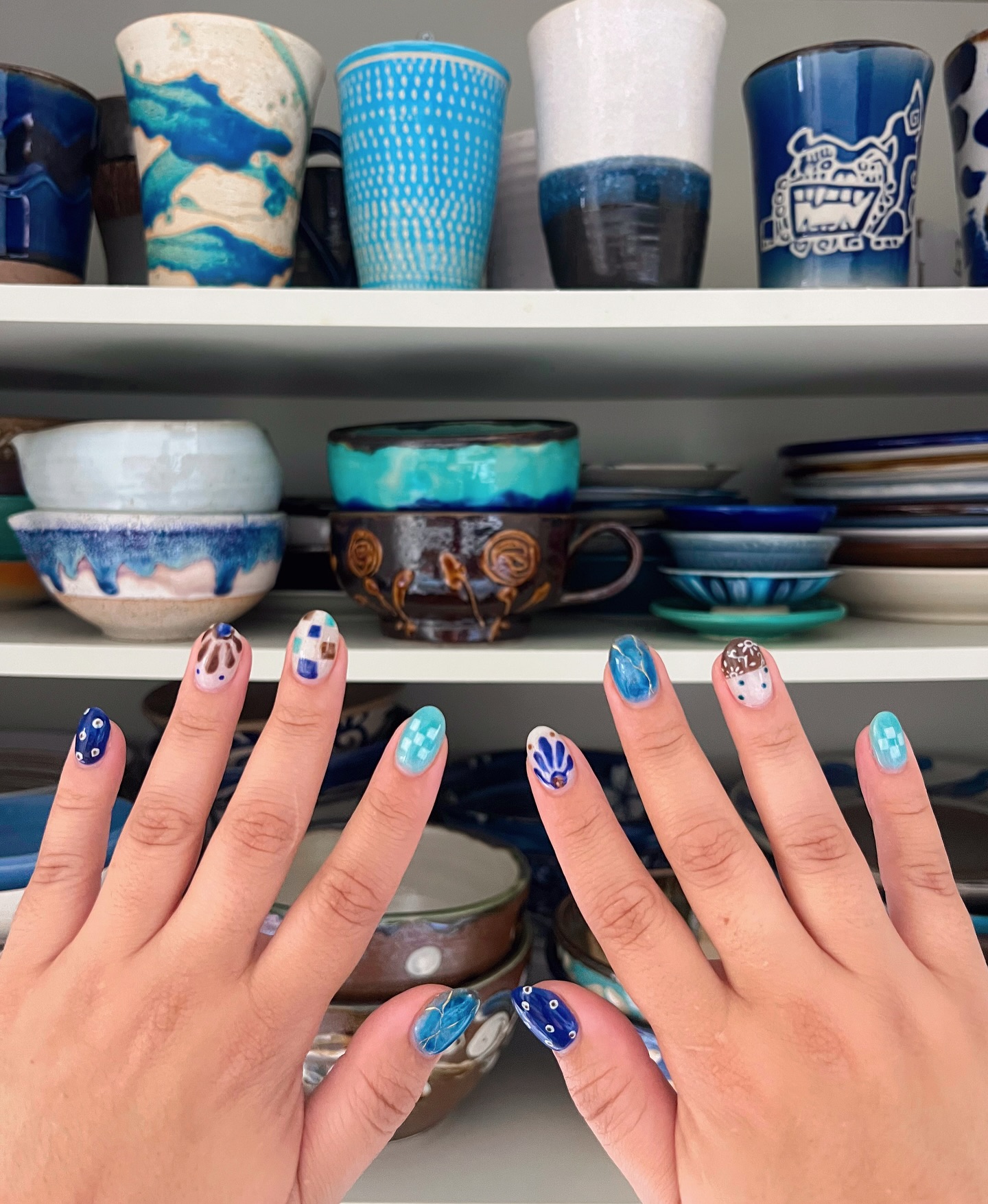 Yachimun mani 🩵💙🤎 

I started getting manicures at a Japanese salon when I began to work full time for my ✨ mental health ✨ and some self care 💅🏼. I started with solid colors, then magnetic polishes, then I treated myself to a fully custom set… and I haven’t been able to look back. 

It’s now been a year and I’ve had the time of my life coming up with monthly dopamine nail designs 🌀! Last month I got a design inspired by Okinawan pottery including a few pieces from own collection 😭 I don’t know how I’m going to surpass this set.

I haven’t been great at taking photos of my nails 🙃 but this set deserved a spot on my feed! Check out my 💅🏼 highlight to see my monthly story videos. Now I’m thinking it’s time to snap some updated photos of my pottery collection 🥹